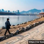 한강 대학생 실종 사건 - A serene riverside scene along the Han River in Seoul during a cold, breezy late afternoon with slip...